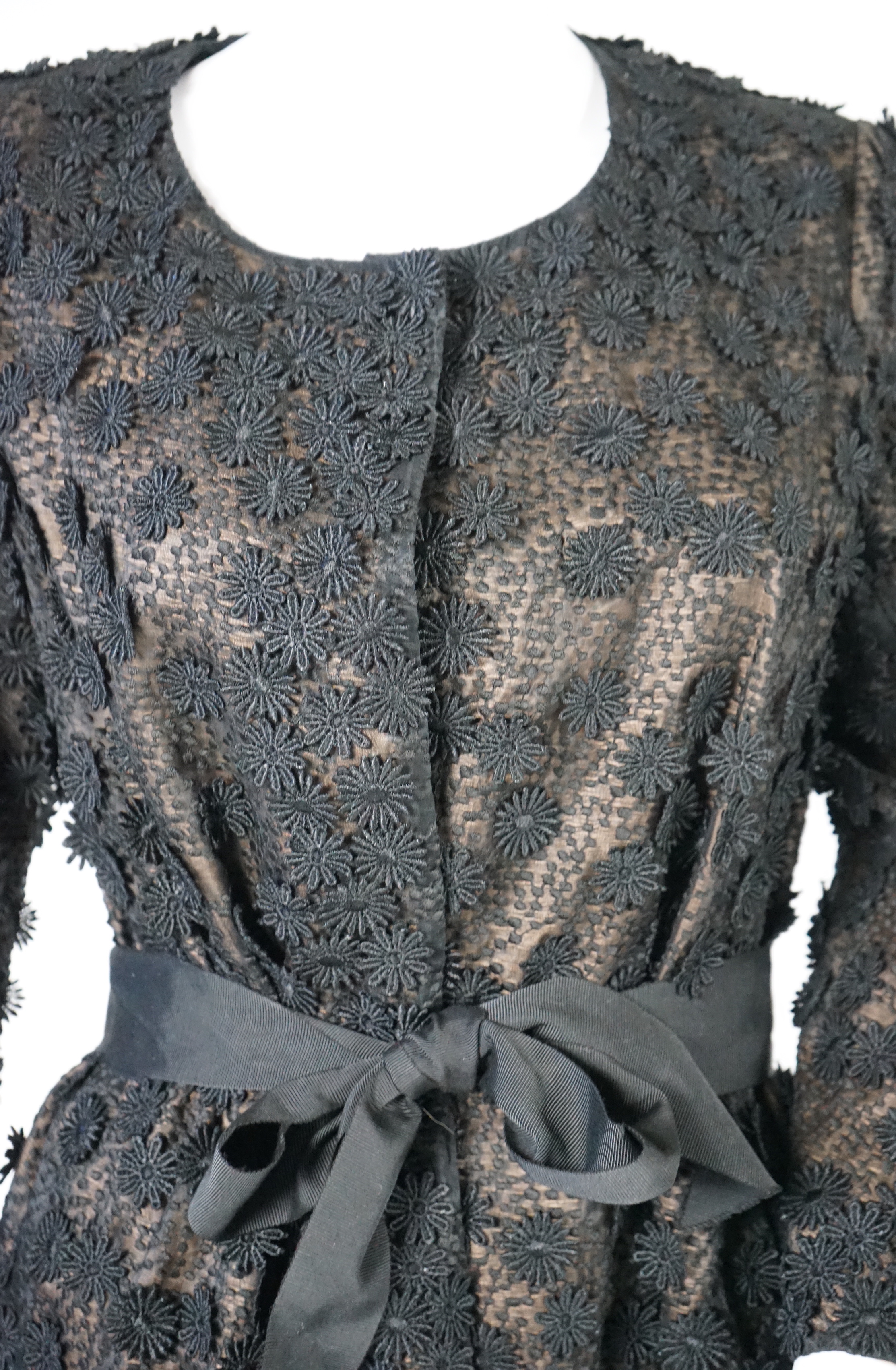 A Nicole Farhi lady's black lace knee length jacket with flower embellishment all over with black ribbon tie belt, size 12